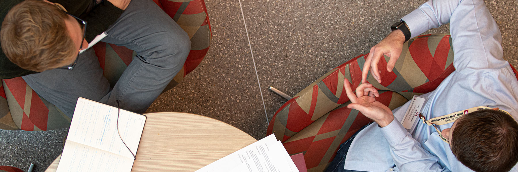 Overhead shot of two people sitting at a table talking.