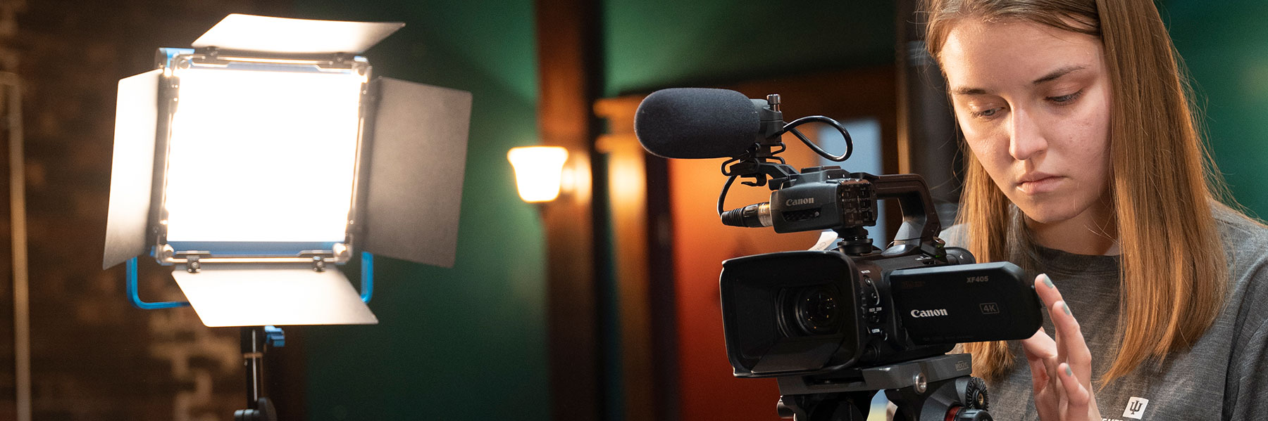 A woman using a video camera in a studio