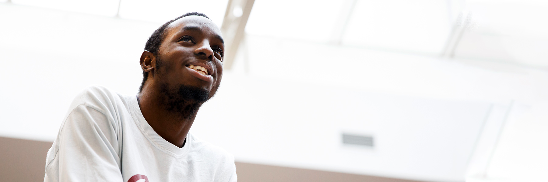 A student smiles in the central commons of Franklin Hall.