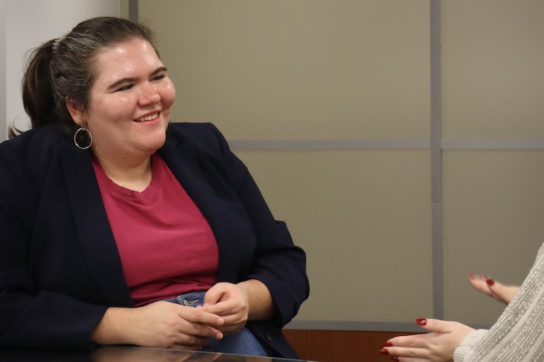 Ellen Hine sits at a table chatting with Emerson Elledge.