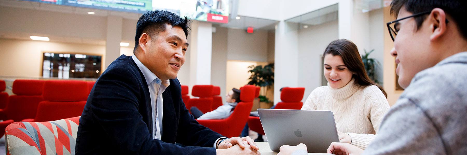 A group of people have a discussion around a table.
